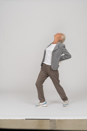 Side view of an old lady in suit doing yoga