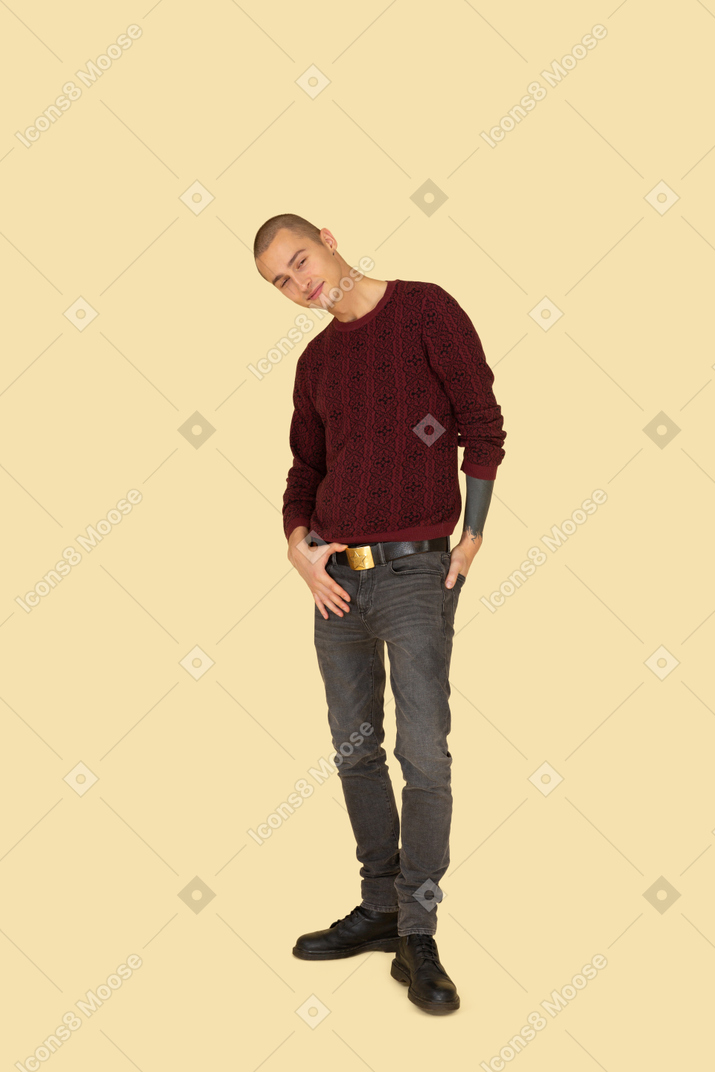 Front view of a young man in red pullover touching his belt