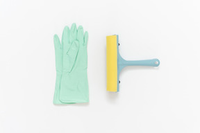 Rubber gloves and a glass wiper lying near each other on the plain white background