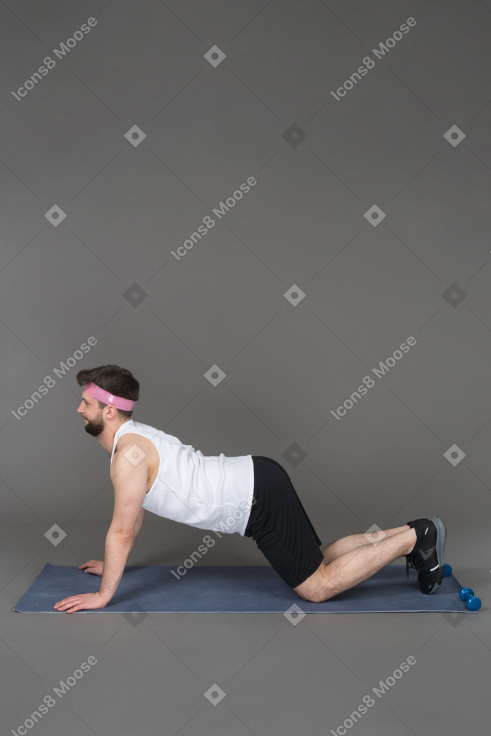 Young man performing arching exercise