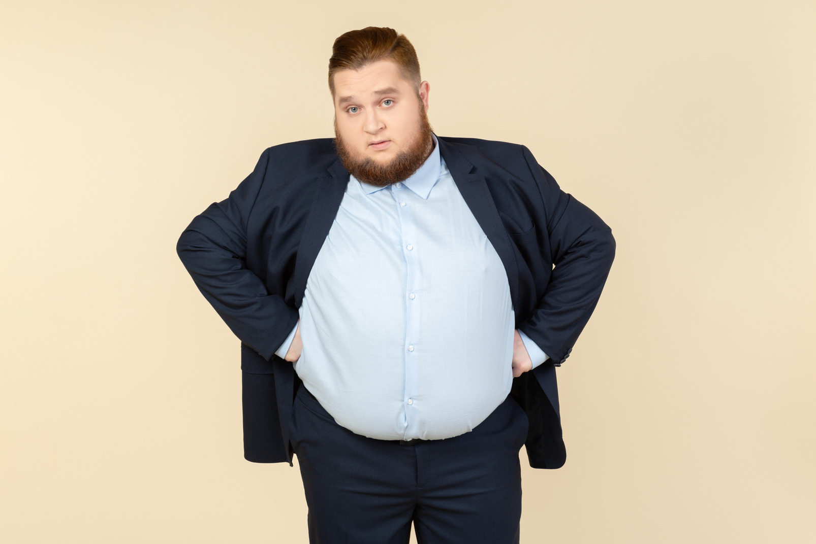 Young overweight man with hands on both sides standing and like not understanding something