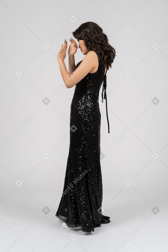 Женщина в черном вечернем платье скрывает лицо