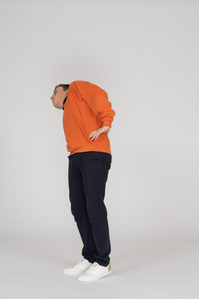 Jeune homme en sweat-shirt orange posant