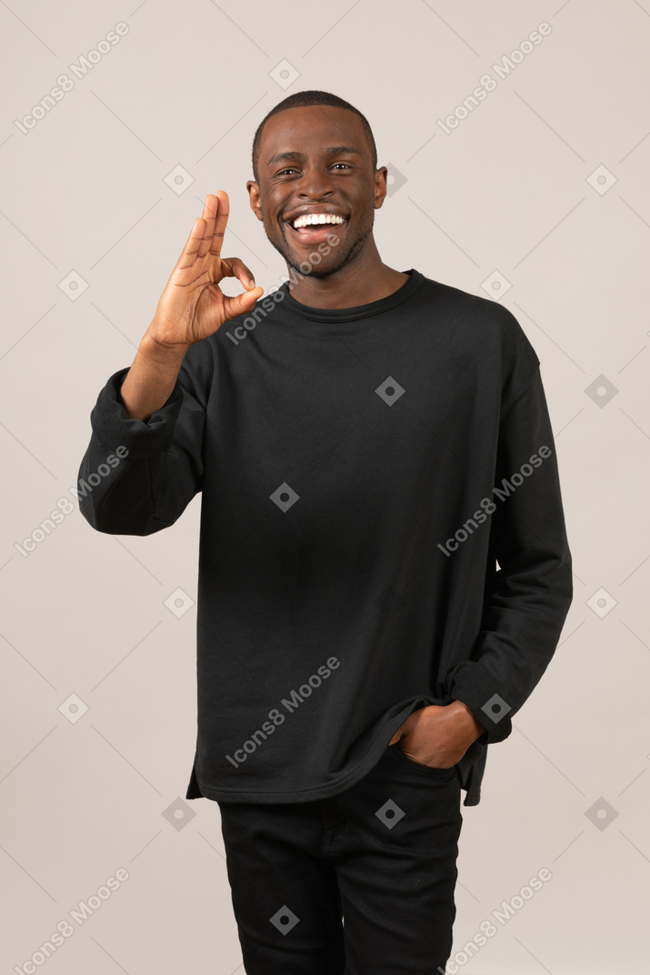 Homme souriant montrant un geste correct