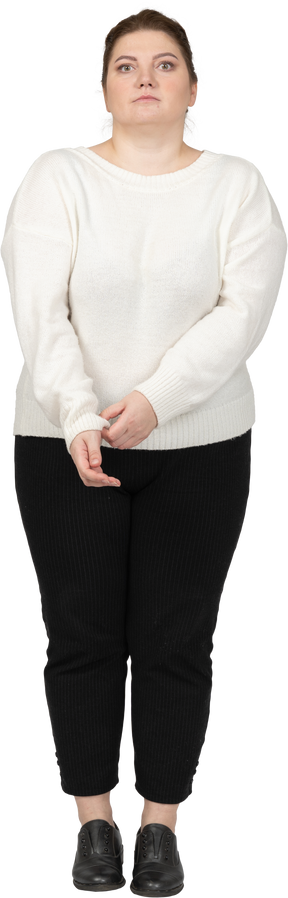 Vista frontal de uma mulher plus size em roupas casuais arregaçando a manga