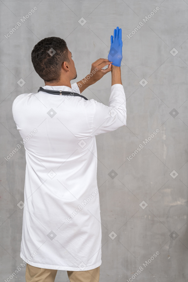 医療用手袋を着用する医師の背面図