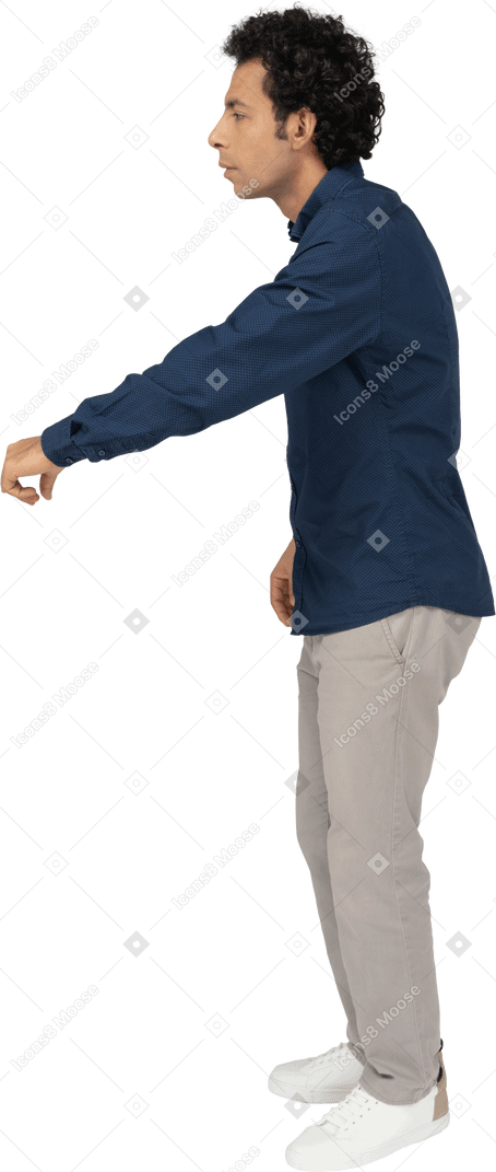 Vue latérale d'un homme en vêtements décontractés debout avec le bras tendu