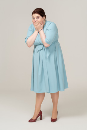 Вид спереди потрясенной женщины в синем платье