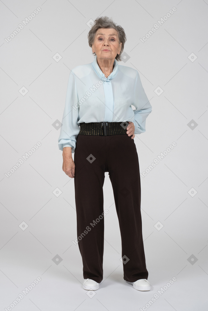 Old lady looking at camera with hand at side