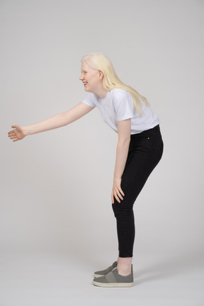 Smiling young woman reaching her arm out