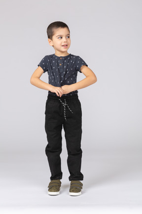 Вид спереди симпатичного мальчика в повседневной одежде, смотрящего в сторону