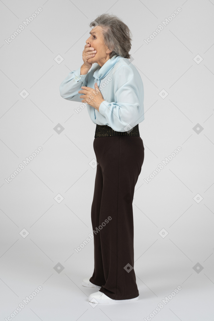 Side view of old lady covering mouth with hand
