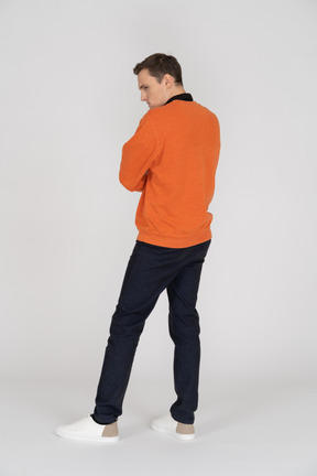 Jeune homme en sweat-shirt orange debout