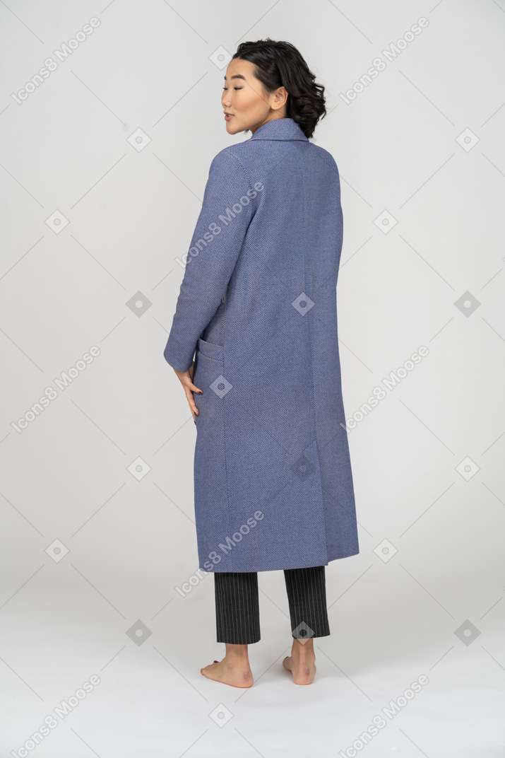 Back view of a woman in blue coat with head turned