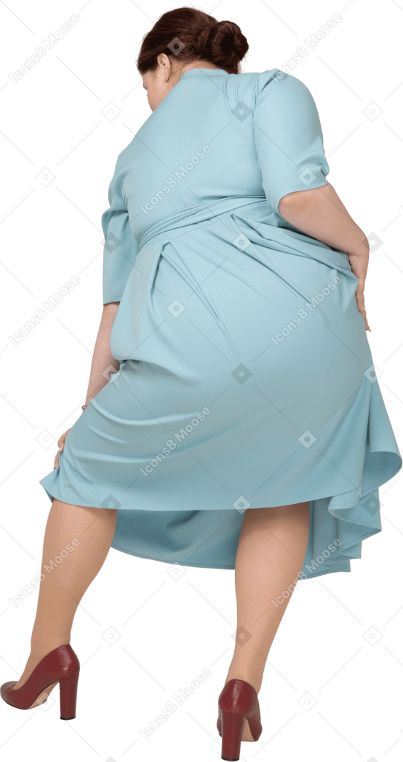 Rear view of a woman in blue dress posing