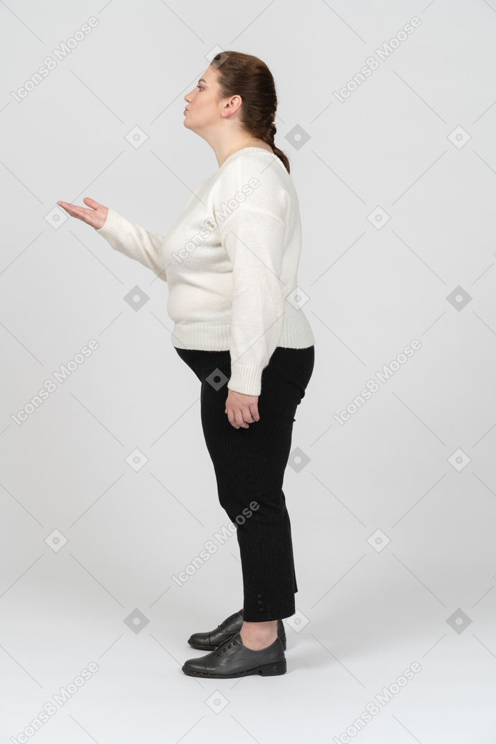 Plump woman in casual clothes blowing a kiss