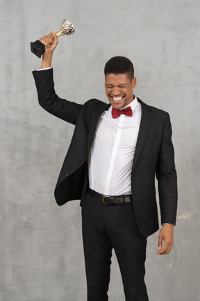 Man holding up award in celebration of his win