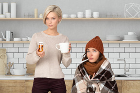 Woman giving pills and tea to sick friend