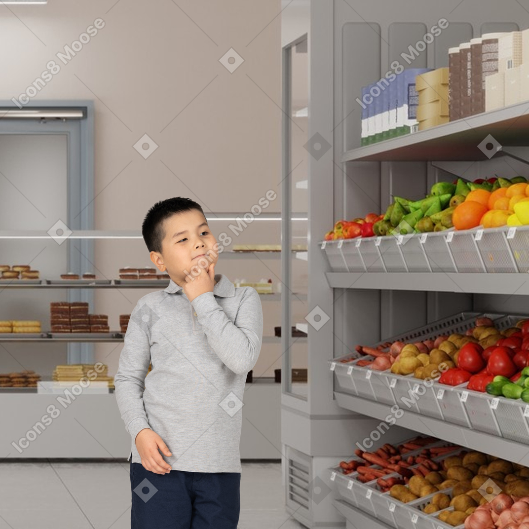Menino escolhendo frutas e legumes no supermercado