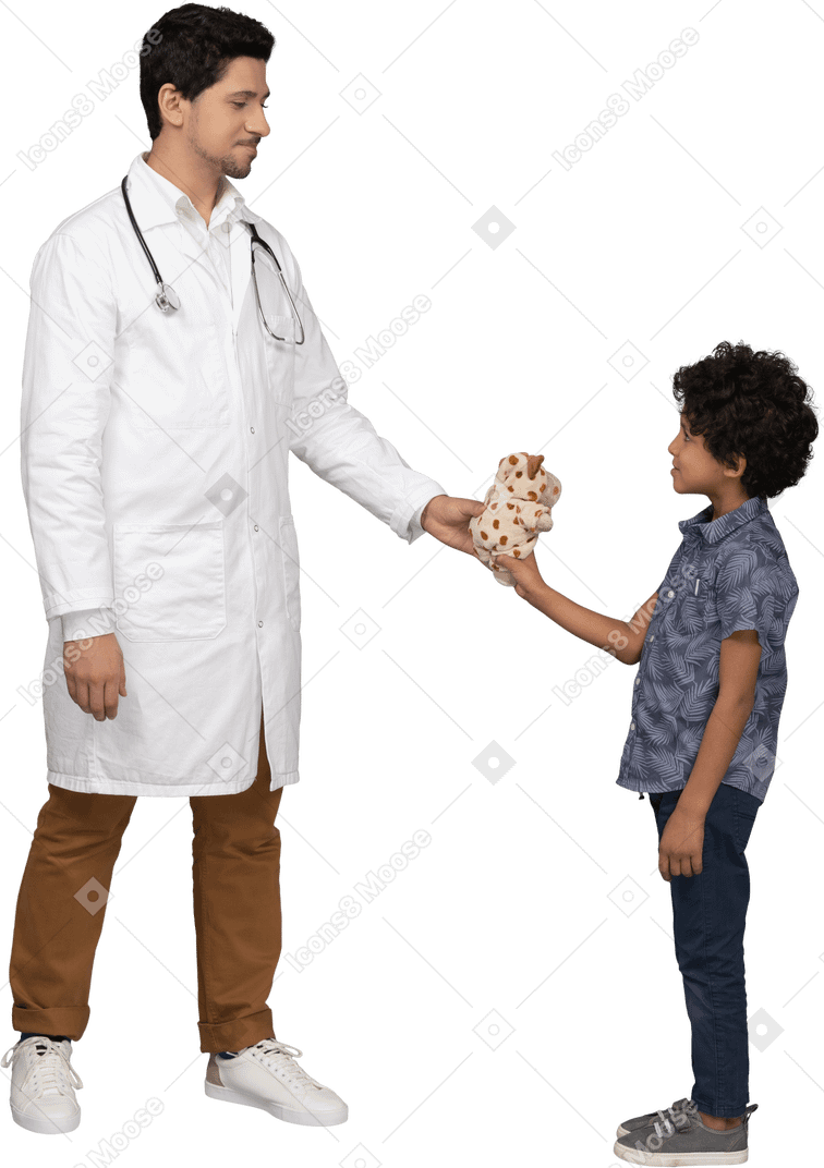 Doctor dando un juguete a un niño pequeño