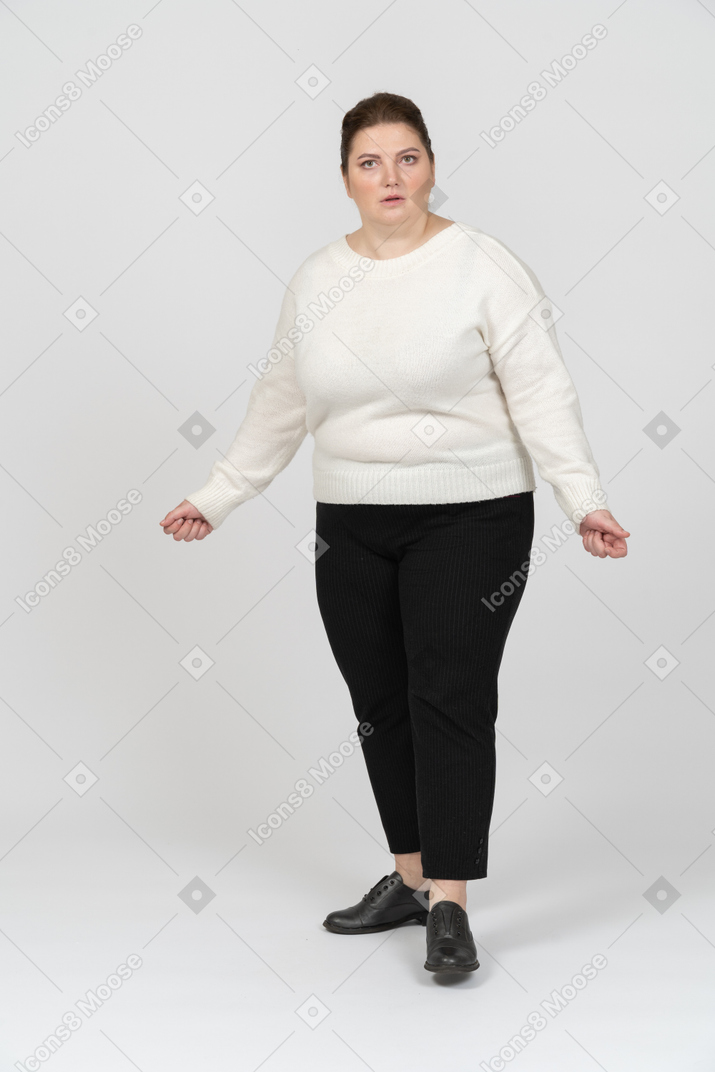 Surprised plump woman in casual clothes looking at camera