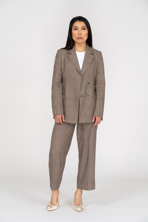 Front view of a displeased pouting young lady in brown business suit