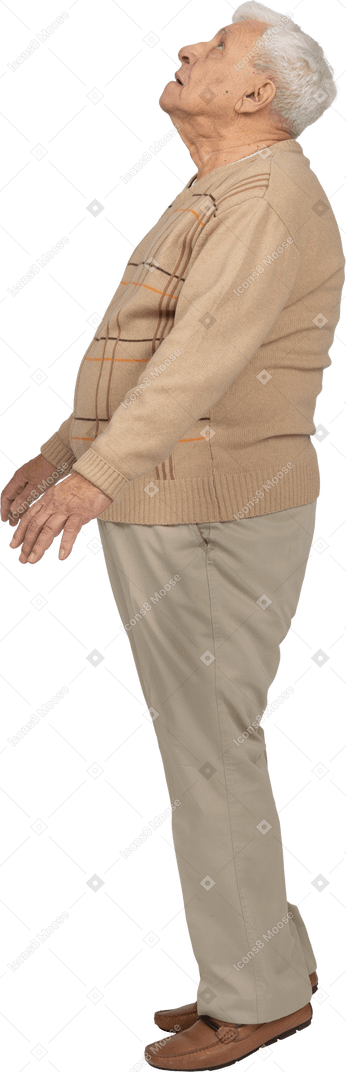 一位穿着休闲服的老人站在脚趾上抬头仰望的侧视图