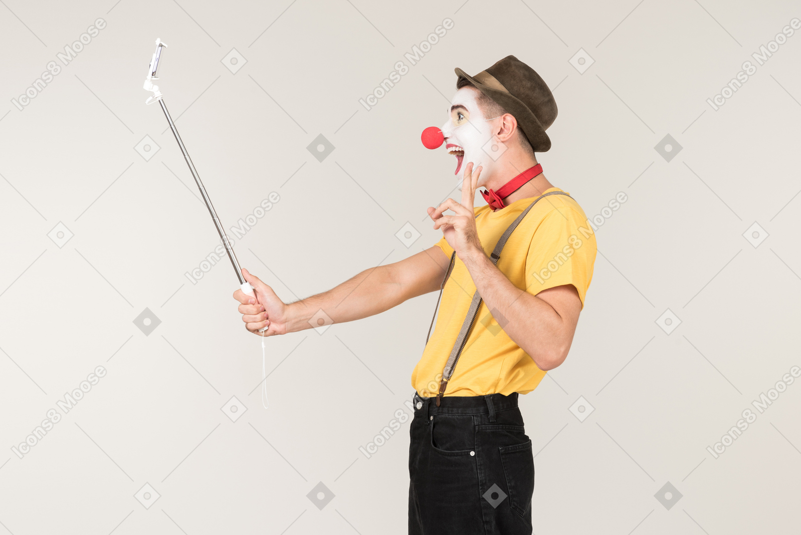 Male clown showing peace gesture and making a selfie