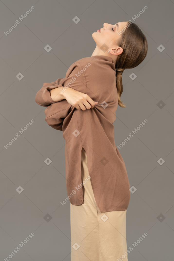 Side view of a woman with crossed arms talking her shirt off