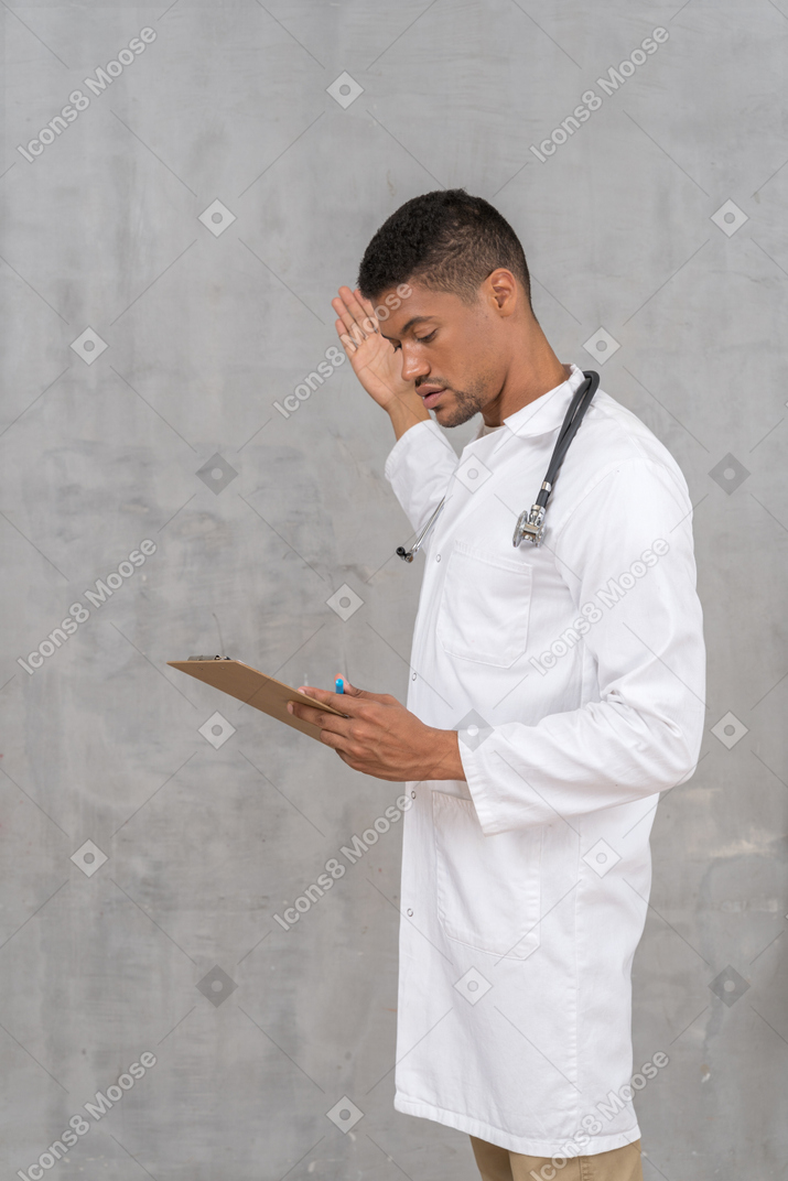 Doctor mirando el portapapeles y haciendo gestos