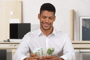 Hombre sonriente contando dinero