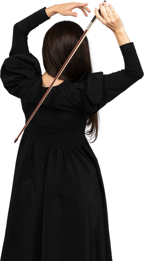 Vista de trás de uma jovem de vestido preto segurando o arco atrás