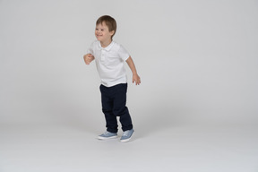 Vista de tres cuartos de un niño ligeramente inclinado hacia adelante con una sonrisa