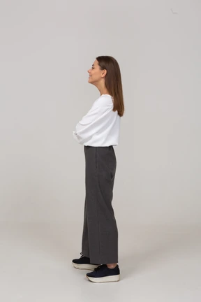 Side view of a smiling young lady in office clothing looking aside