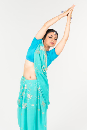 Jeune femme indienne en sari bleu debout en position de danse