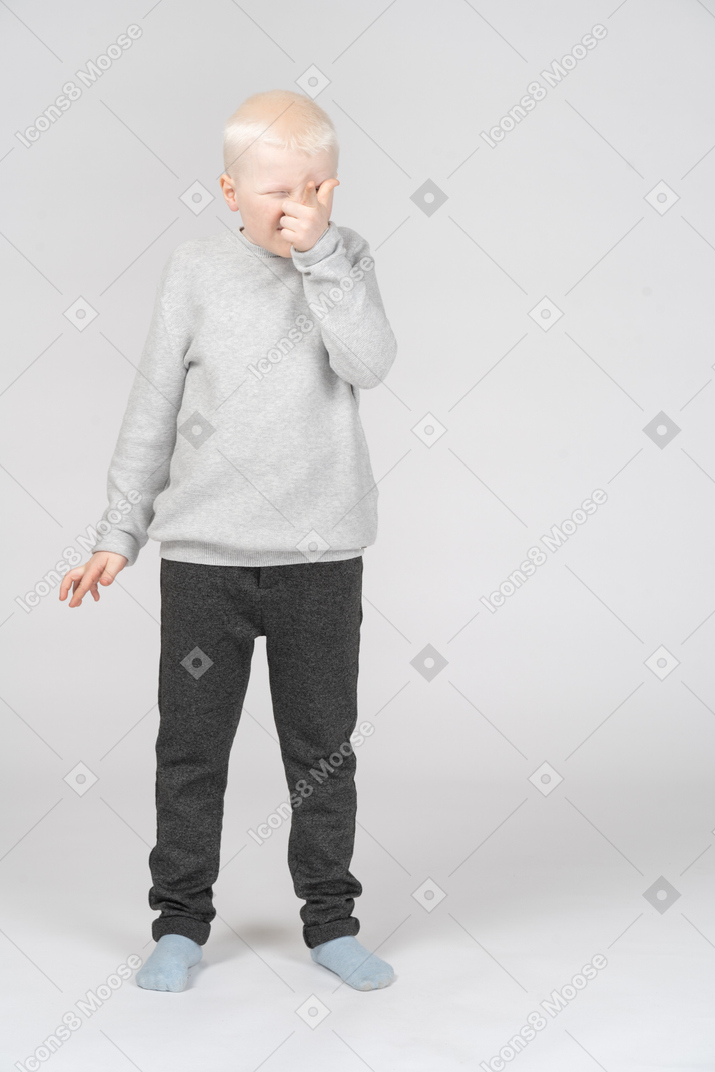 Little boy pointing at camera with finger gun