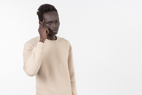 A young black man in a grey sweater standing alone on the white background