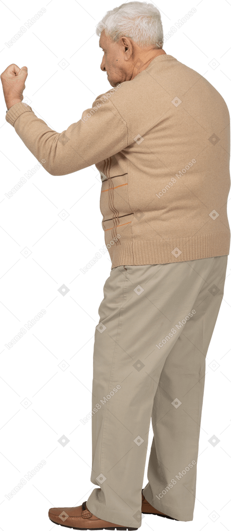 Vista lateral de un anciano con ropa informal que muestra el puño