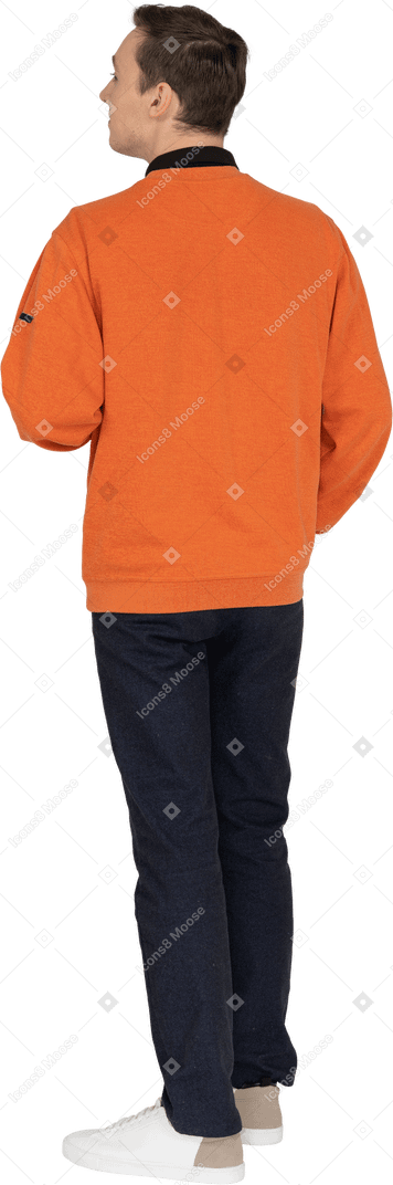Junger mann im orangefarbenen sweatshirt stehend