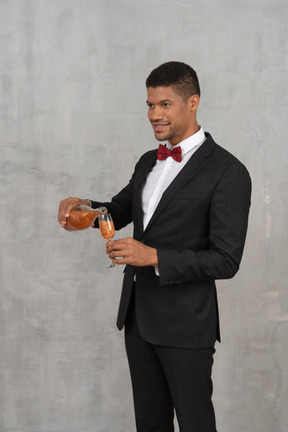 Young man pouring liquor into a champagne glass