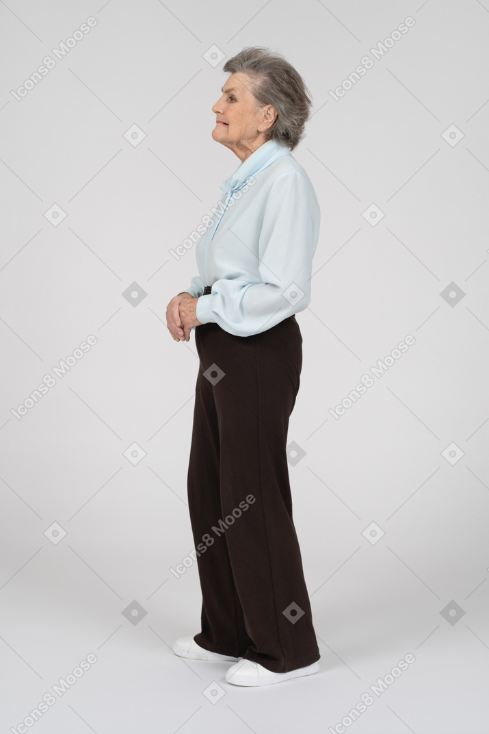 Vista lateral de una anciana haciendo muecas con los labios fruncidos