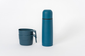 Thermos bleus et gobelets en plastique sur fond blanc