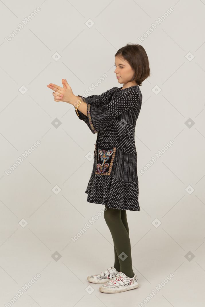 Vista lateral de uma menina atirando em um vestido