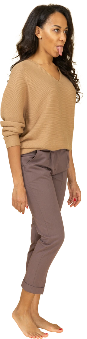Three-quarter view of a young female in casual clothes showing tongue