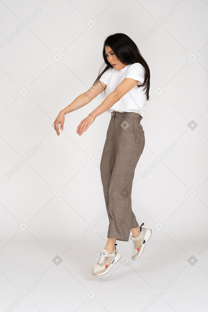 Three-quarter view of a young lady in breeches and t-shirt outstretching hands