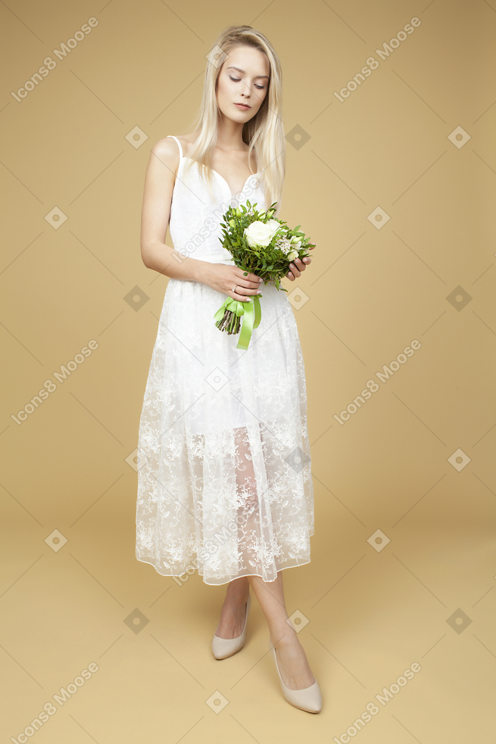 Beauitufl bride holding wedding bouquet and posing for a photo