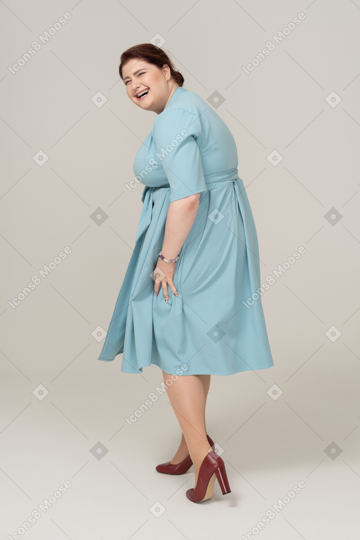 Woman in blue dress posing in profile