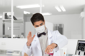 A man in a lab coat conducting experiment with a test tube