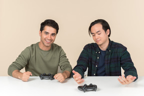 Interracial friends sitting at the table and playing video game