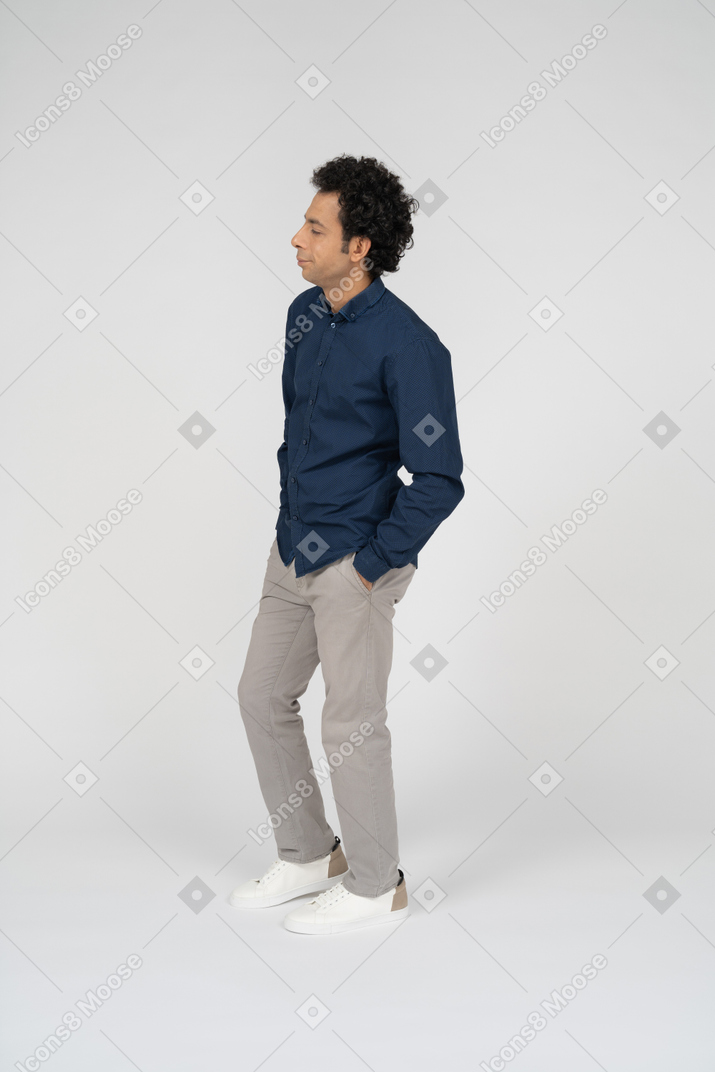 ポケットに手を入れて立っているカジュアルな服を着た男の側面図